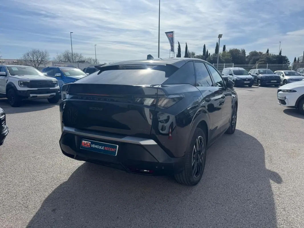 Vue 3/4 arrière droite d’un Peugeot 3008 Hybrid 145 noir avec jantes alliage 19 pouces, stationné en extérieur.