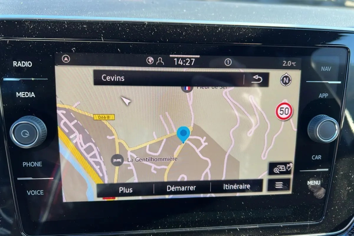 Écran tactile central du Volkswagen T-Cross blanc pur, affichant la navigation GPS avec carte et options de trajet.