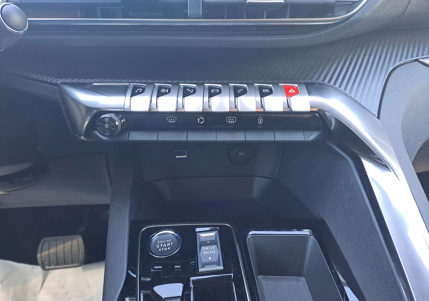 Vue intérieure centrée sur la console centrale du Peugeot 3008 2023, avec boutons de commande et finition noire brillante.