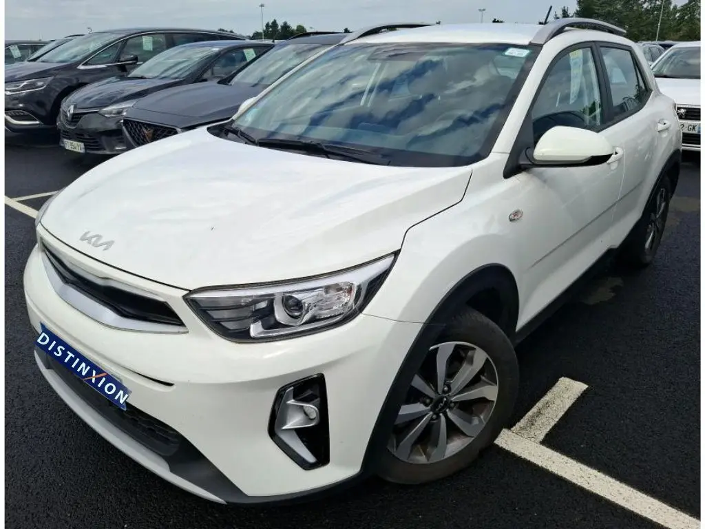 Vue 3/4 avant droite d’un KIA Stonic blanc 2023 avec détails noirs sur les passages de roues et calandre.