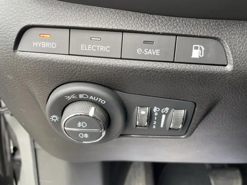 Vue rapprochée des commandes d'éclairage et modes hybride du tableau de bord du Jeep Compass gris 2023.