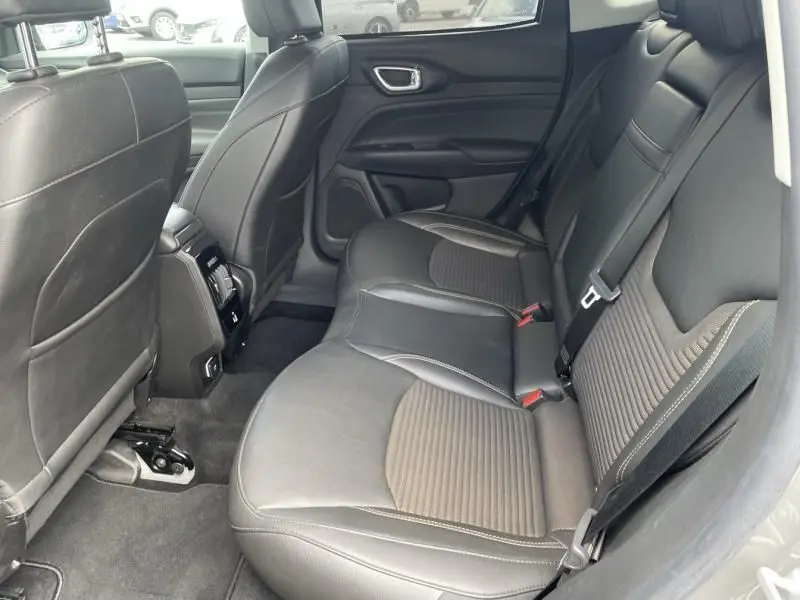 Vue intérieure arrière droite des sièges en cuir noir du Jeep Compass 2023 gris hybride rechargeable.