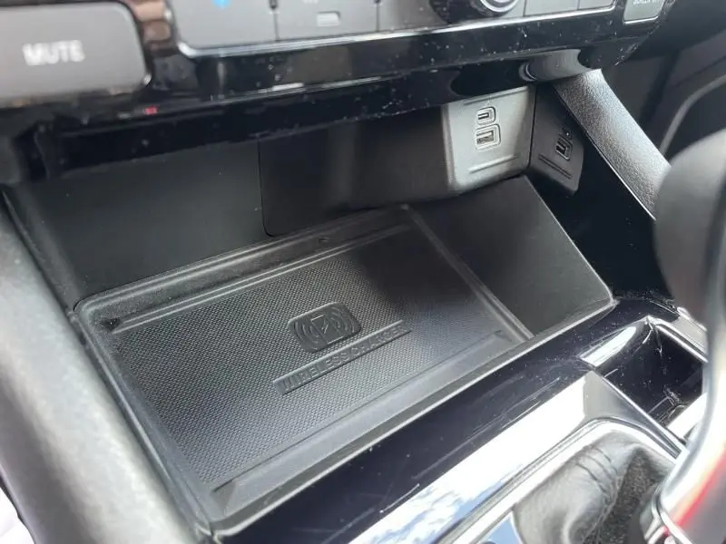 Gros plan sur le chargeur sans fil et ports USB du Jeep Compass gris 2023, version hybride rechargeable 4Xe.