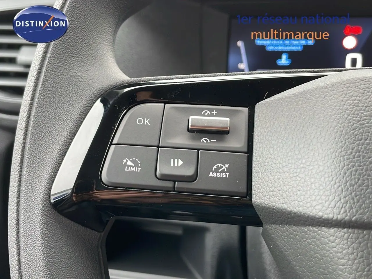 Gros plan sur les commandes au volant noir du Peugeot Expert Fourgon blanc, version 2025, montrant les boutons de régulateur et limiteur de vitesse.