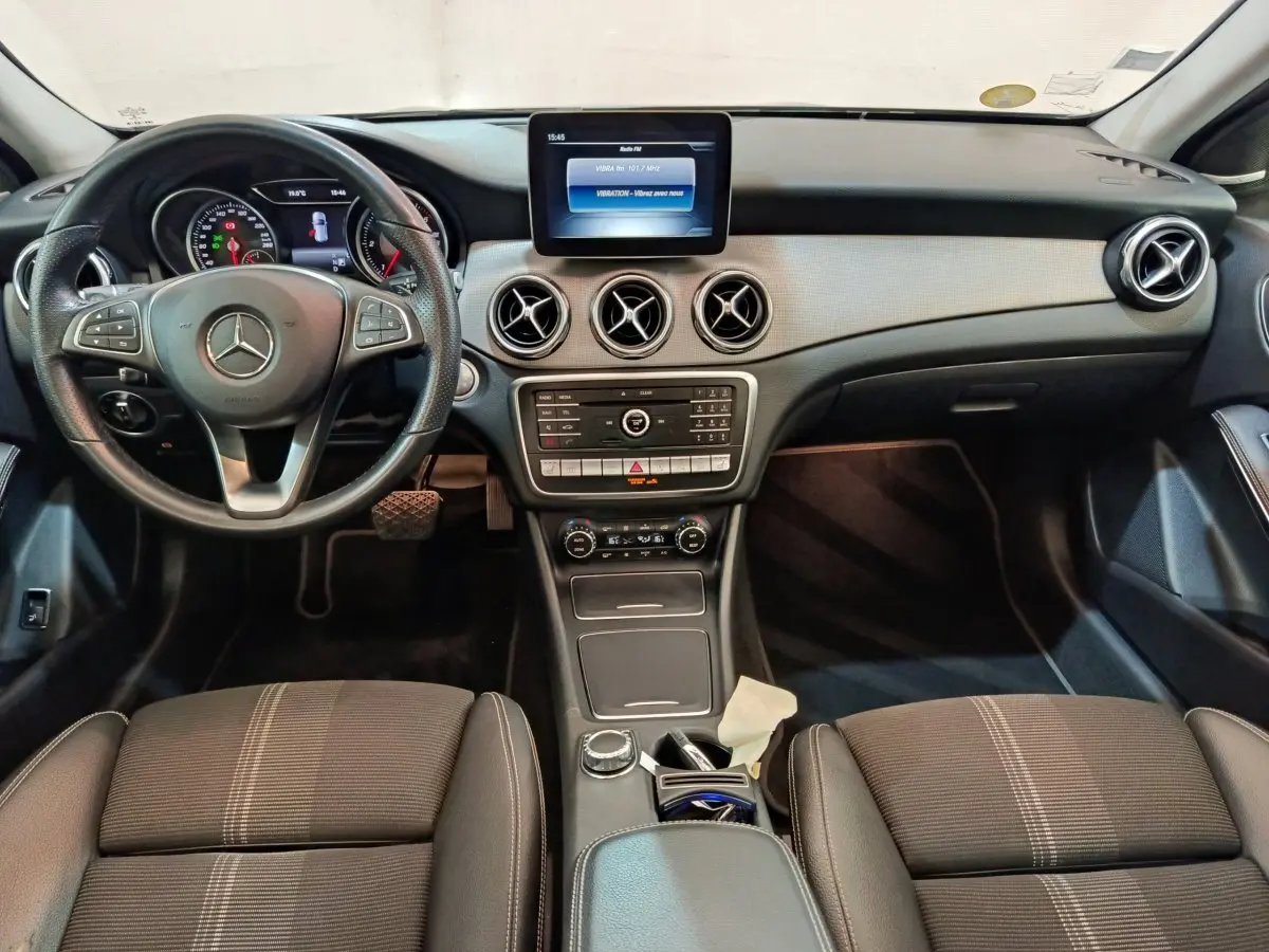 Vue intérieure avant du Mercedes GLA 220 d noir, tableau de bord avec écran central et volant cuir multifonctions.