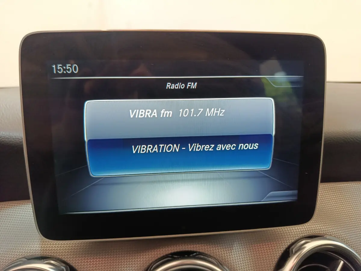 Écran multimédia affichant la radio FM dans l'habitacle du Mercedes GLA 220 d Business Exec noir, vue intérieure frontale.