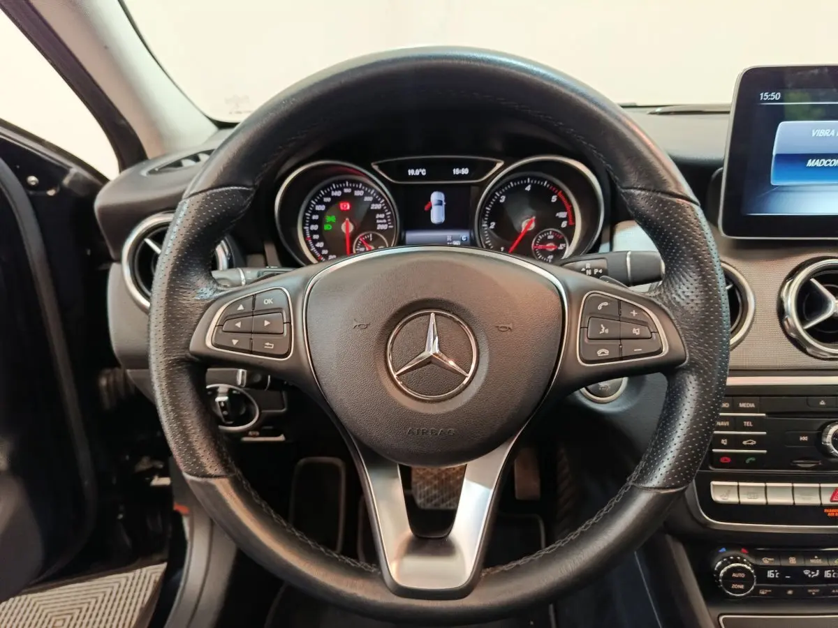 Vue rapprochée du volant cuir noir multifonctions d'une Mercedes GLA 220 d Business Exec 2018 avec tableau de bord numérique.
