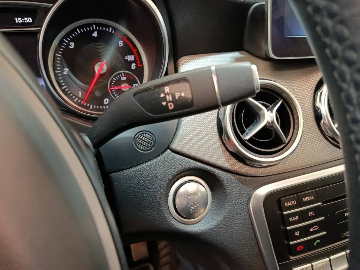Détail intérieur du tableau de bord noir du Mercedes GLA 220 d 2018 avec bouton démarrage et commandes de boîte automatique.