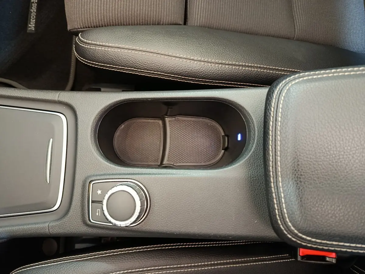 Vue rapprochée de la console centrale noire du Mercedes GLA 220 d avec molette de commande et accoudoir en cuir.