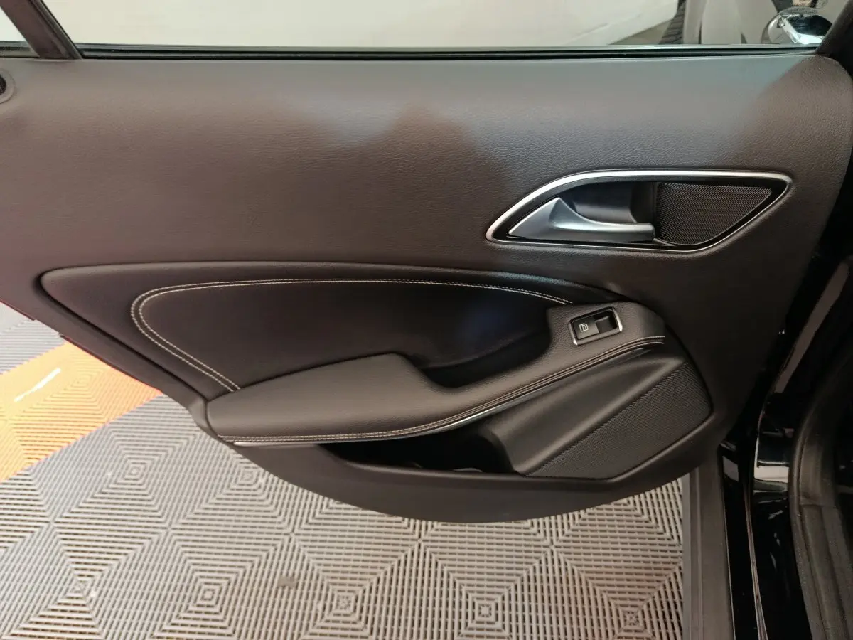 Gros plan sur la porte intérieure côté gauche noire du Mercedes GLA 220 d Business Exec Edit 2018 avec surpiqûres blanches.