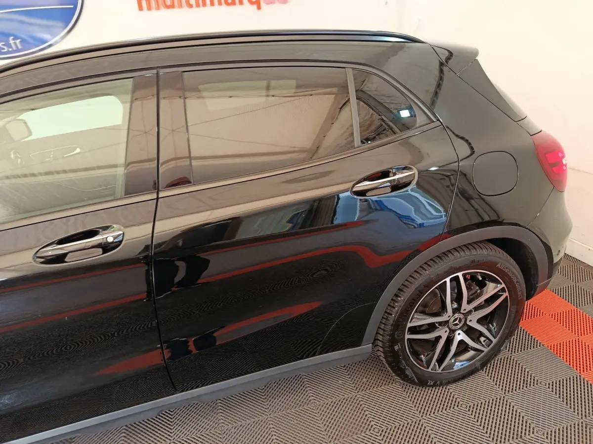 Vue latérale droite du Mercedes GLA 220 d noir brillant, mettant en valeur la jante alliage et les poignées chromées.