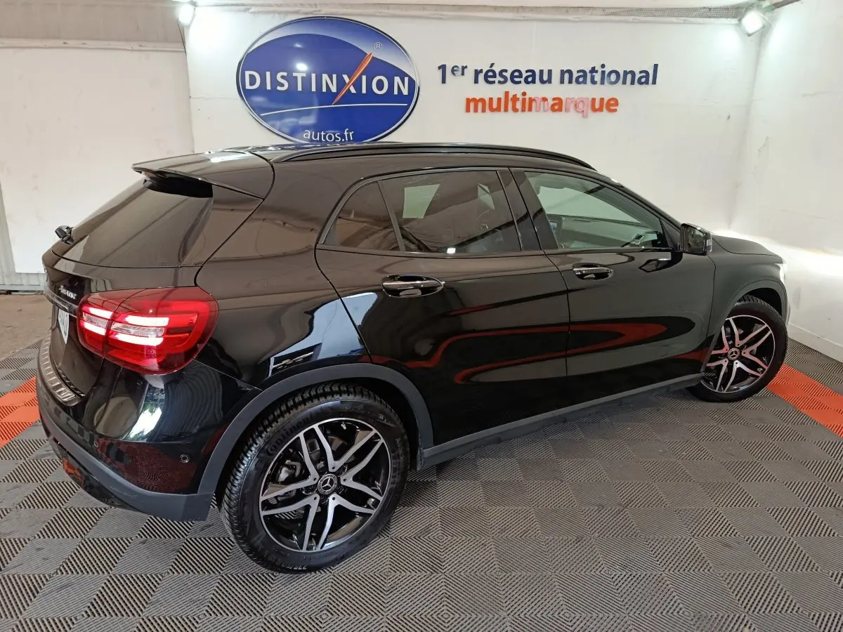 Mercedes GLA 220 d noir vue 3/4 arrière droit, avec jantes alliage et feux arrière LED en intérieur showroom.