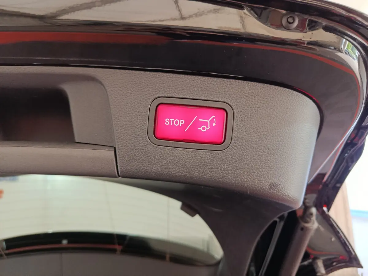 Bouton rouge stop ouverture coffre électrique sur hayon intérieur d’un Mercedes GLA noir 2018