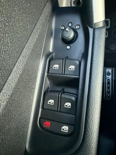 Gros plan sur les commandes de lève-vitres et rétroviseurs noirs côté conducteur de l'Audi Q2 35 TFSI 2023.