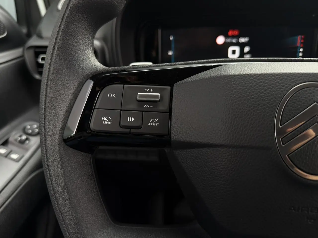 Gros plan sur le volant noir de la Citroën Berlingo 2026, avec commandes multifonctions à gauche et logo central visible.