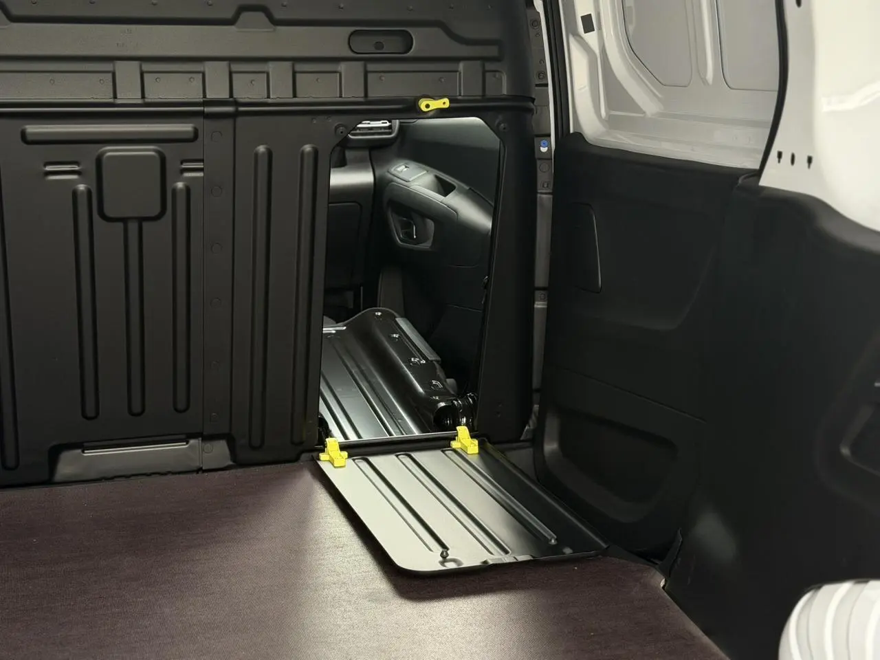 Vue intérieure du coffre côté droit du Citroën Berlingo Van XL blanc avec plancher bois antidérapant et cloison tôlée noire.