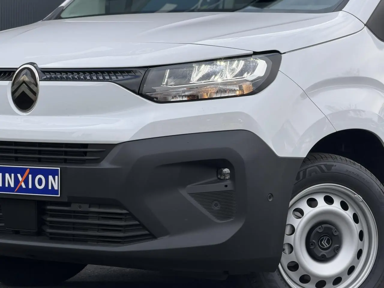 Vue avant droite du Citroën Berlingo blanc Icy avec calandre noire et jante tôle grise 16 pouces.
