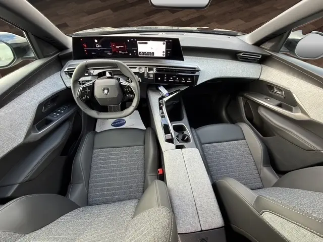 Vue intérieure frontale du Peugeot 3008 gris foncé, avec tableau de bord numérique et volant cuir multifonctions.