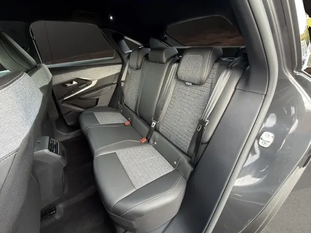 Vue latérale droite de l'intérieur arrière du Peugeot 3008 gris foncé, sièges en cuir et tissu gris avec ceintures de sécurité.