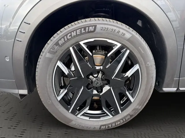 Gros plan sur la jante 19 pouces noire et argentée du côté gauche d’un Peugeot 3008 gris foncé hybride.