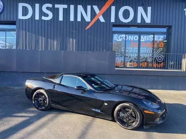 Chevrolet Corvette C6 Targa noire vue de profil côté gauche, avec jantes noires et toit amovible visible.