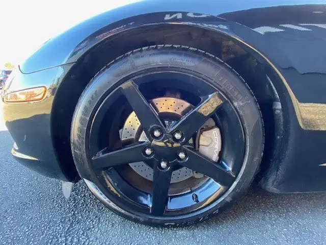 Gros plan sur la roue avant gauche noire d'une Chevrolet Corvette C6 Targa 2005 avec étrier de frein marqué Corvette.