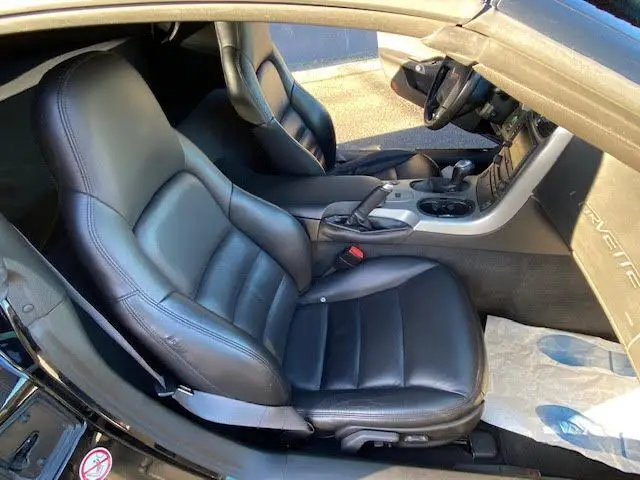 Intérieur noir de la Chevrolet Corvette C6 Targa 2005, vue côté conducteur sur les sièges en cuir et console centrale.