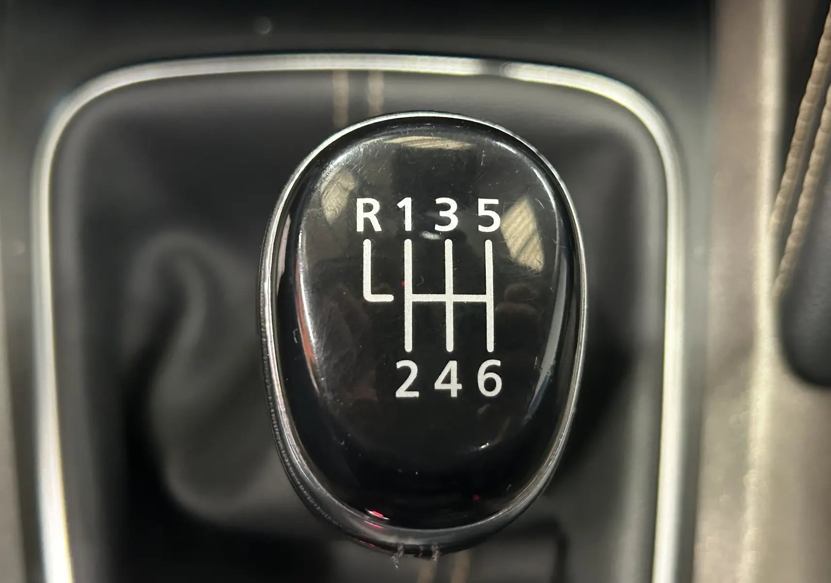 Gros plan sur le levier de vitesses manuel noir du Renault Kadjar gris diesel de 2015, affichant les six rapports et la marche arrière.