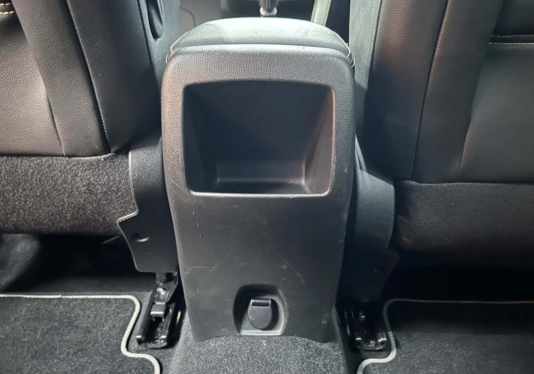 Détail du rangement arrière central noir entre les sièges avant d’un Renault Kadjar gris 2015.