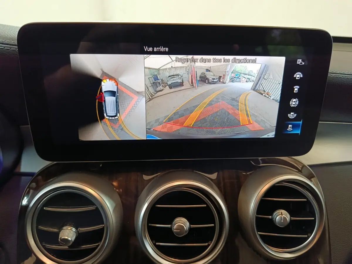 Écran tactile intérieur du Mercedes GLC 300 e Business Line montrant la caméra de recul et l'aide au stationnement.