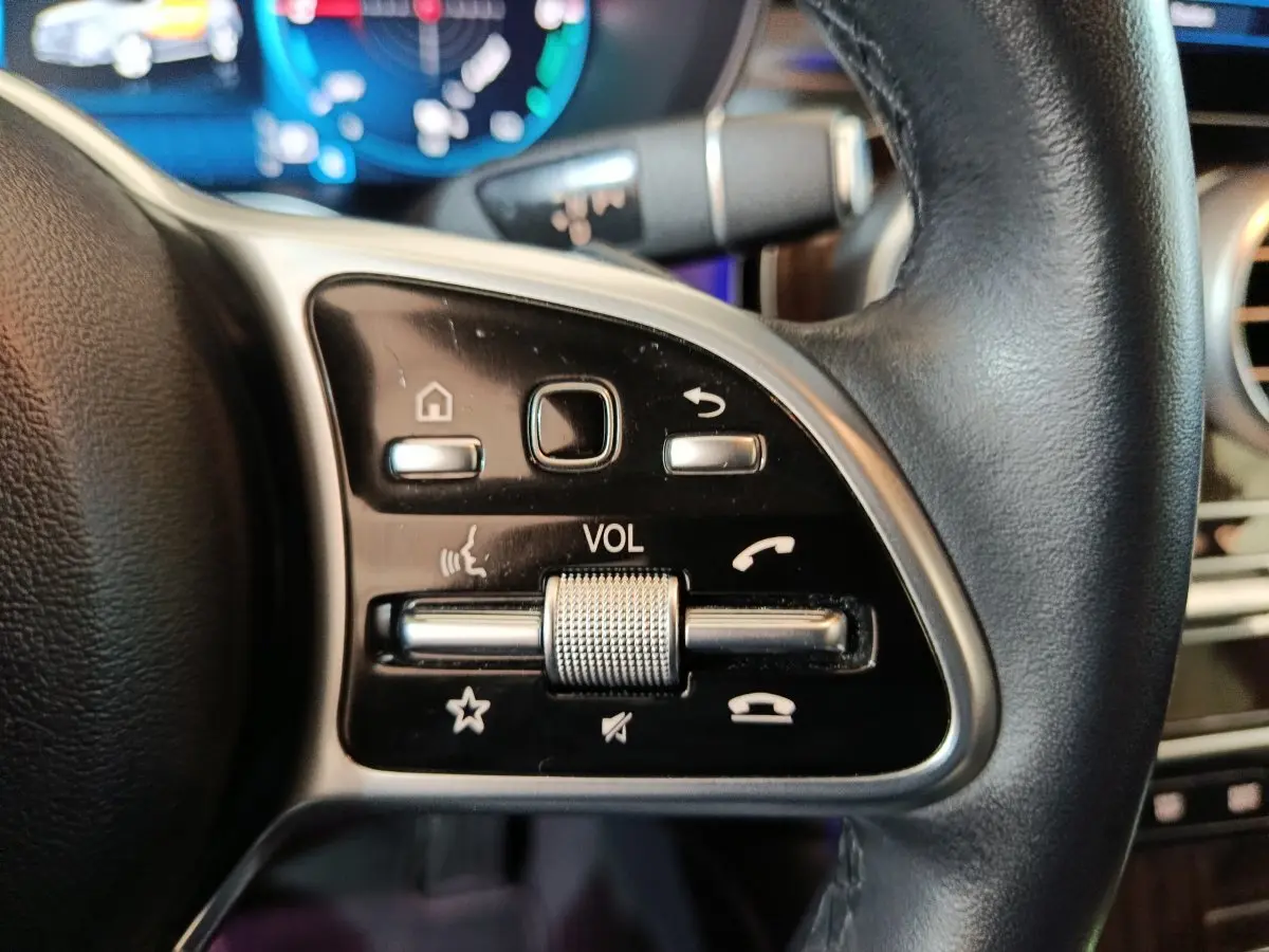 Gros plan sur les commandes noires et argentées du volant cuir du Mercedes GLC 300 e Business Line 2020.