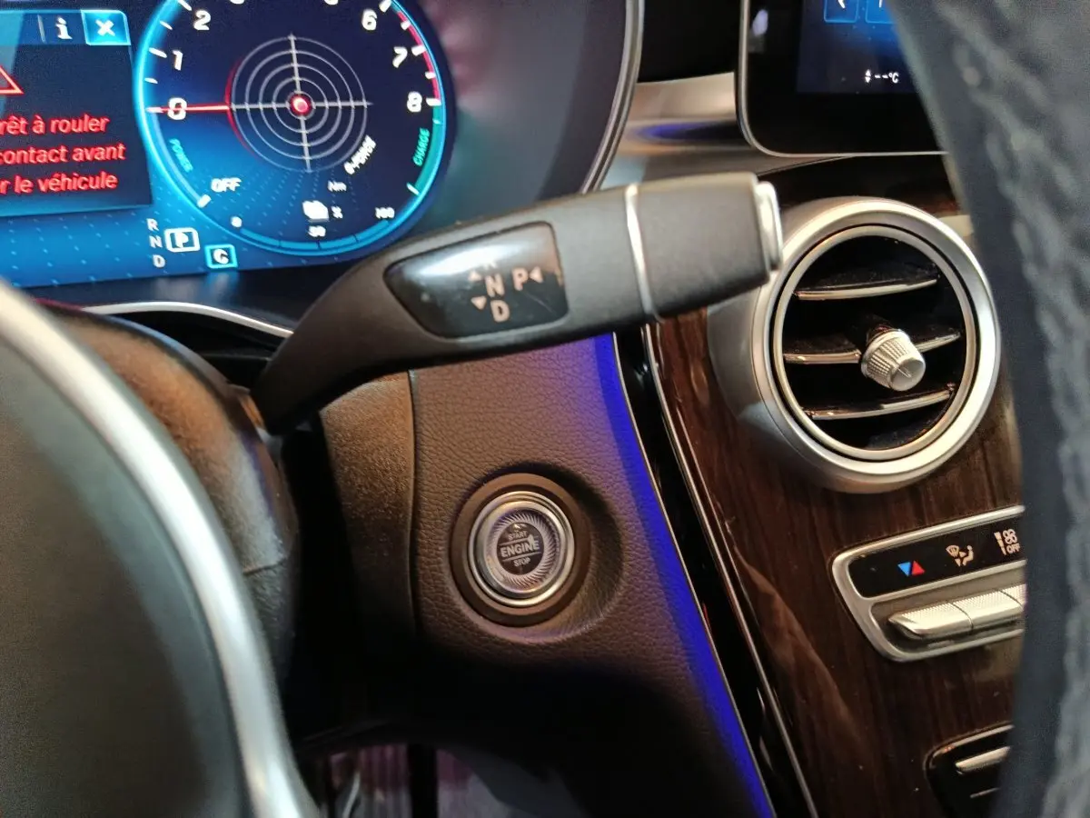 Détail du tableau de bord noir du Mercedes GLC 300 e Business Line 2020, avec bouton démarrage et levier de vitesses.
