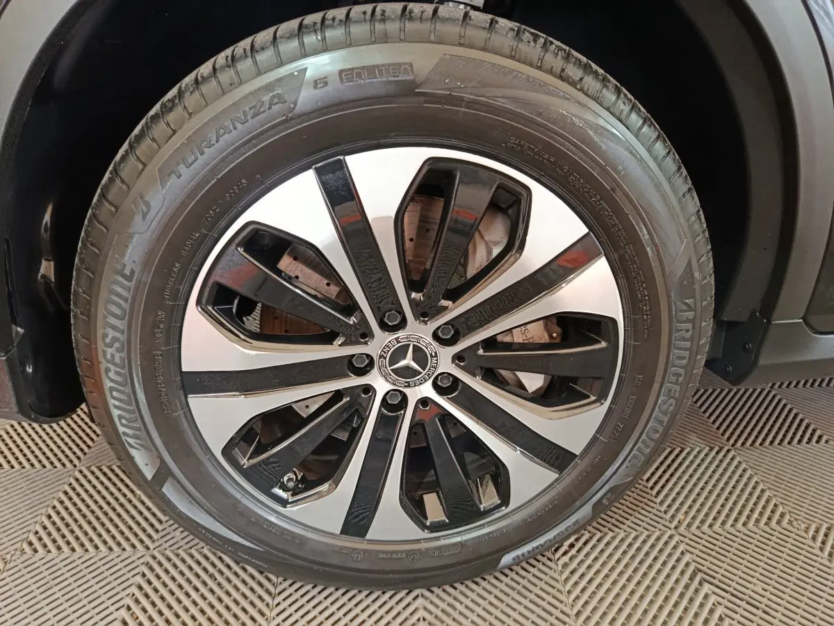 Gros plan sur la roue avant droite du Mercedes GLC 300 e noir, jante alliage bicolore et pneu Bridgestone Turanza.