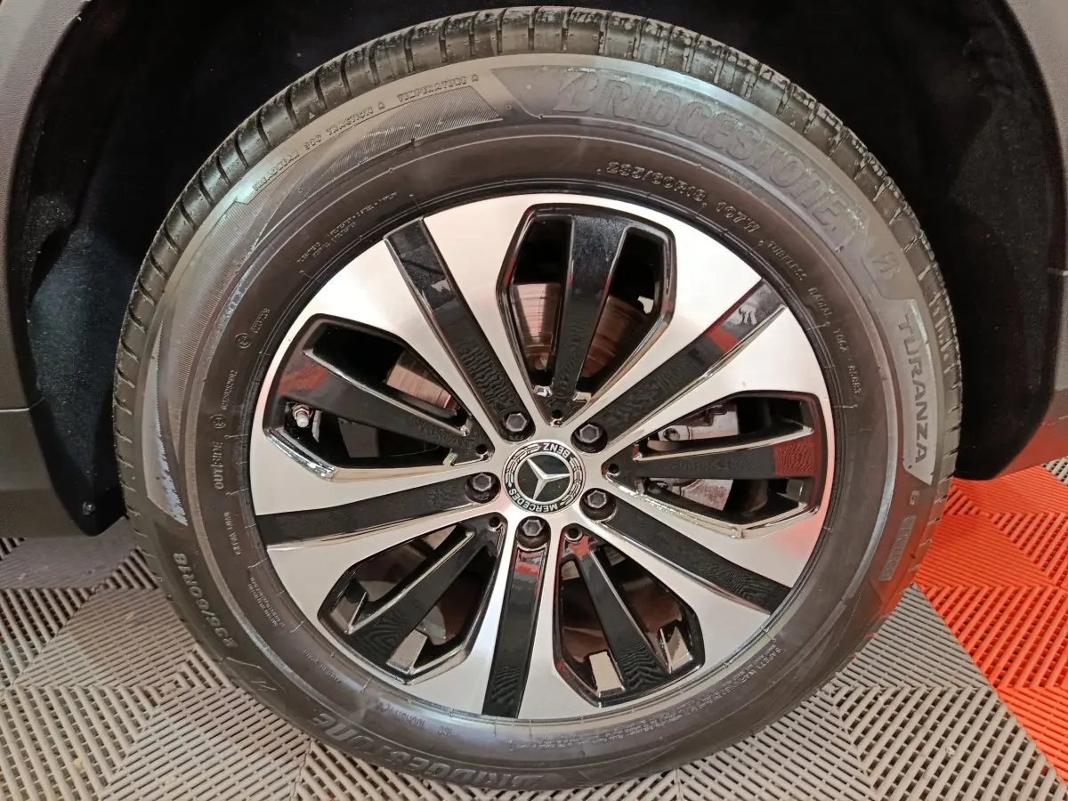 Gros plan sur la jante alliage bicolore et pneu Bridgestone du Mercedes GLC 300 e Business Line noir de 2020.