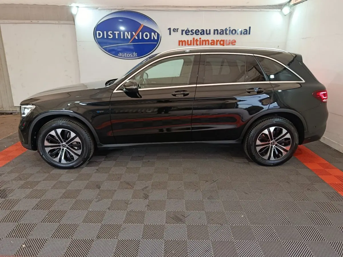 Profil côté gauche d'un Mercedes GLC 300 e Business Line hybride rechargeable noir, roues alliage et feux arrière LED visibles.