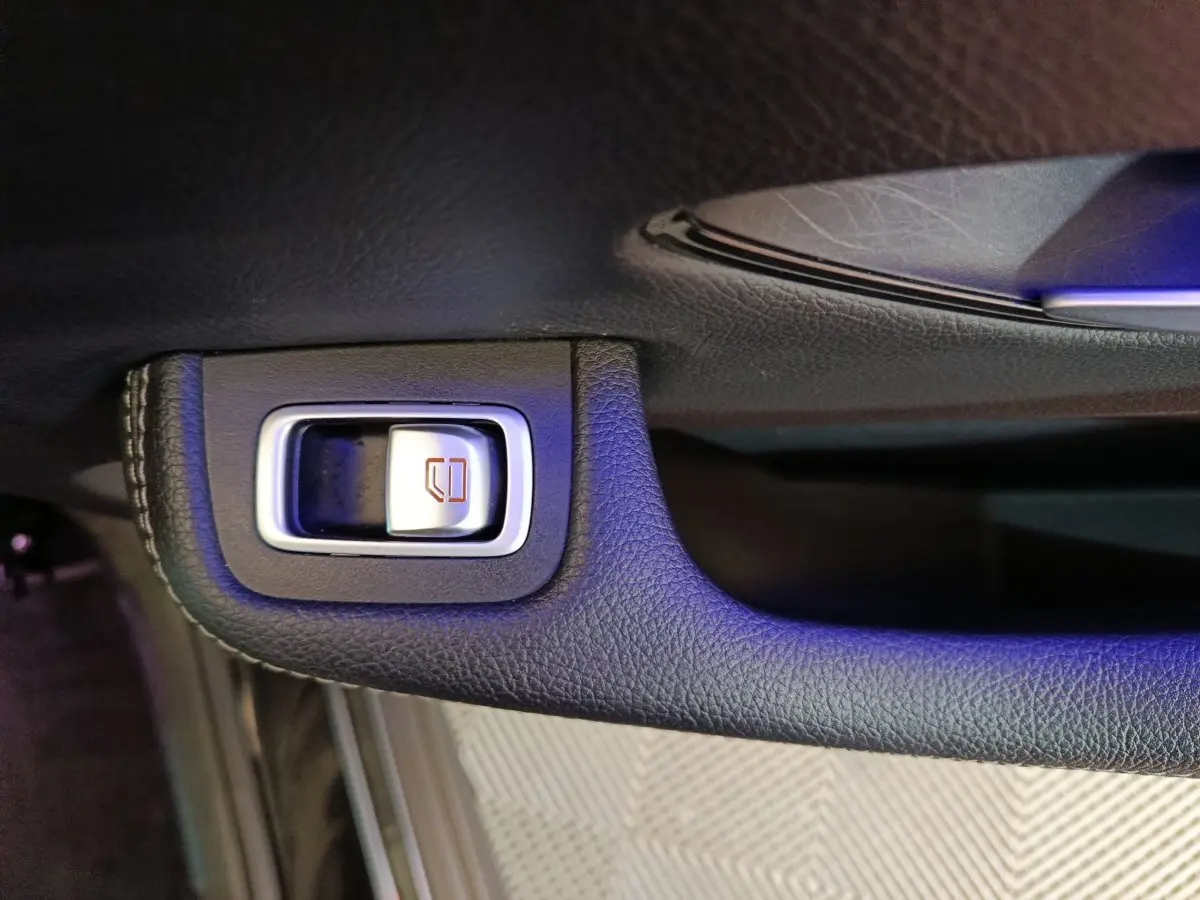 Gros plan sur le bouton de verrouillage des vitres en cuir noir à l'intérieur d'une Mercedes GLC 300 e Business Line 4Matic.