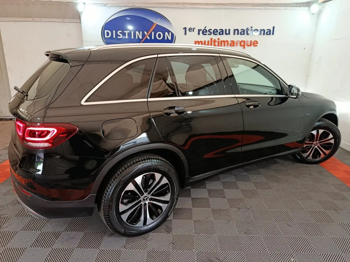 Vue 3/4 arrière droite d'un Mercedes GLC 300 e Business Line noir avec jantes alliage et feux LED allumés.