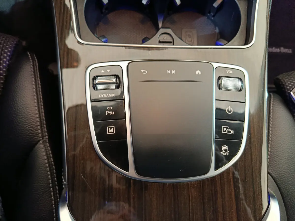 Gros plan sur la console centrale en bois avec pavé tactile et commandes du Mercedes GLC 300 e Business Line noir.