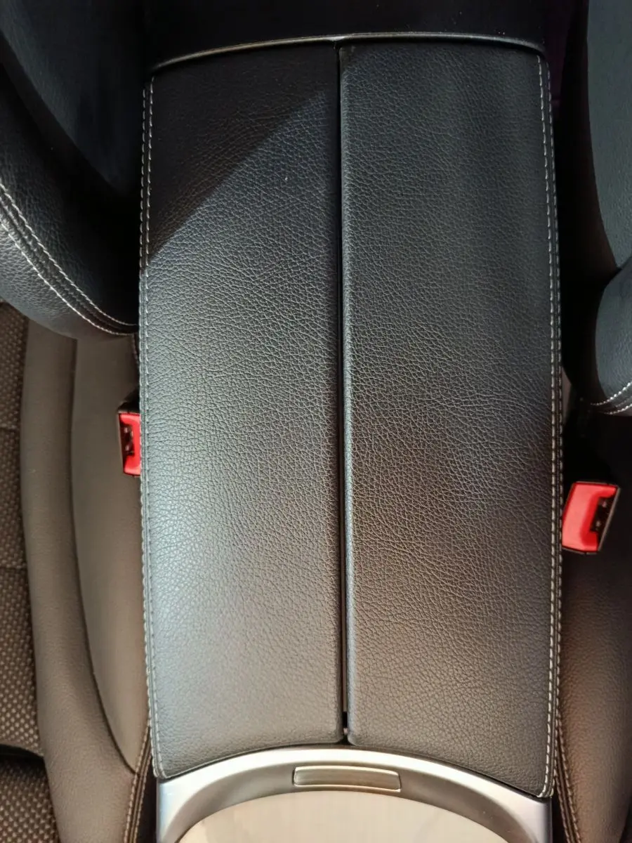 Gros plan sur l'accoudoir central en cuir noir avec surpiqûres blanches dans l'habitacle du Mercedes GLC 300 e.