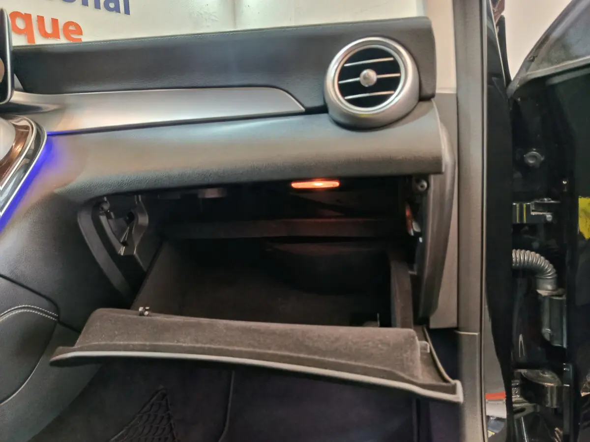 Gros plan sur la boîte à gants ouverte côté passager du Mercedes GLC 300 e Business Line noir 2020.