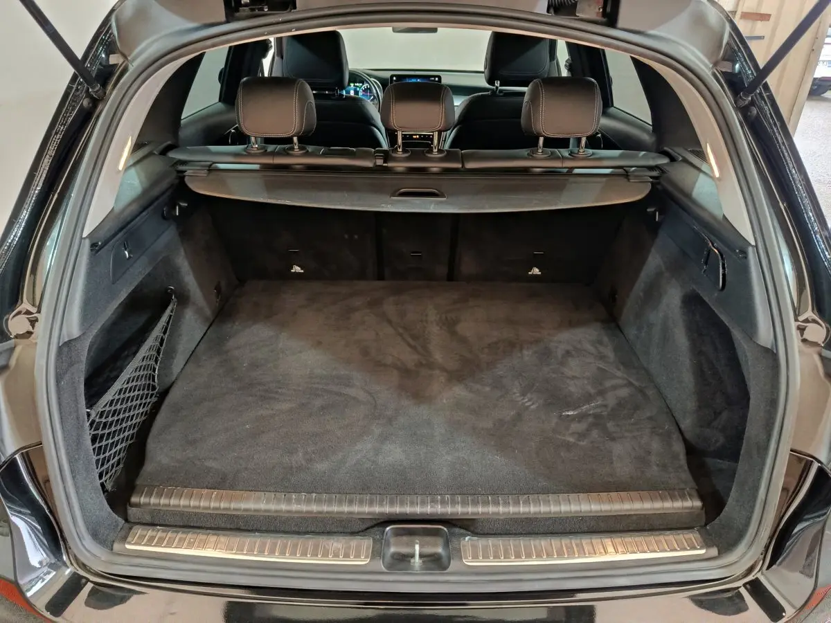 Coffre ouvert vu de l'arrière d'un Mercedes GLC 300 e Business Line noir, espace de chargement propre et spacieux.