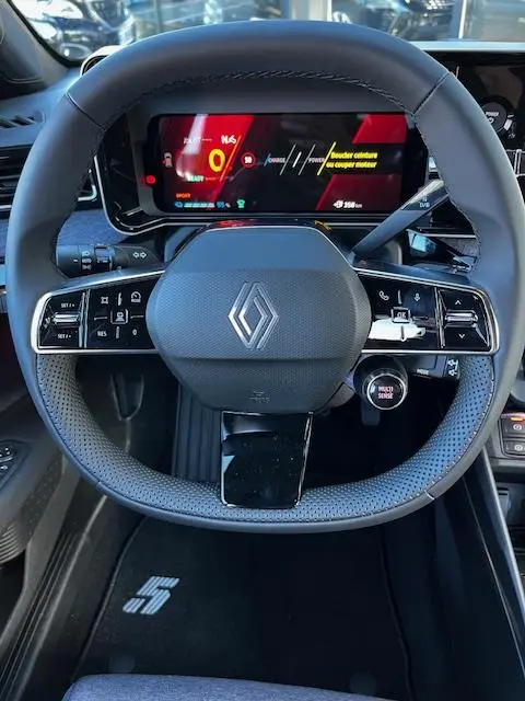 Vue centrée sur le volant noir de la Renault R5 électrique 2024 avec tableau de bord numérique et logo Renault visible.
