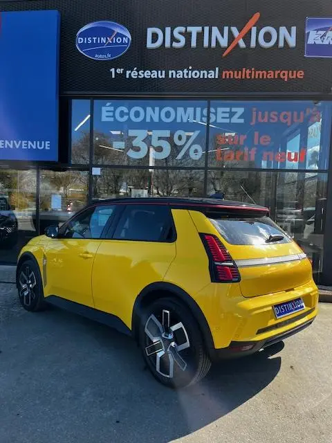 Vue 3/4 arrière droite d'une Renault R5 Techno jaune électrique 2024, avec feux arrière LED distinctifs et jantes stylisées.