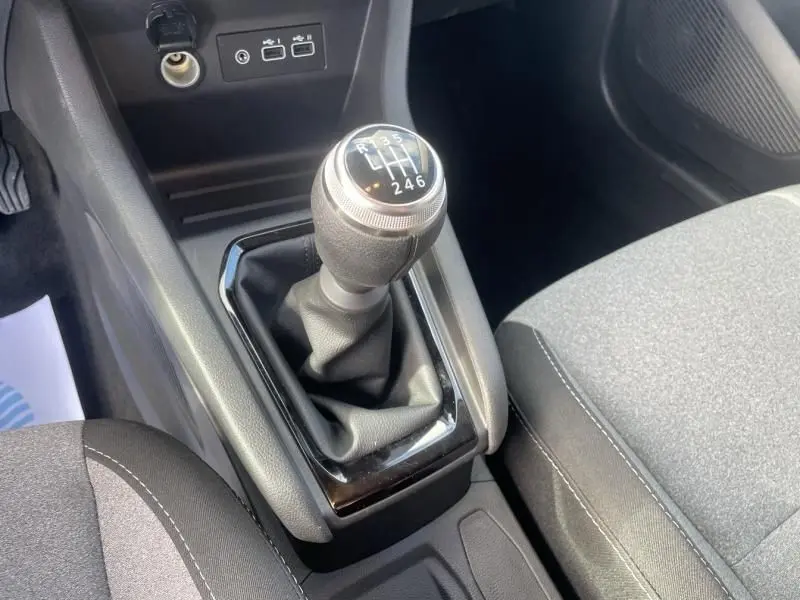 Le levier de vitesse manuel de la Renault Clio V 1.5 DCI 100 Evolution 2025 en noir, vu en gros plan côté console centrale.