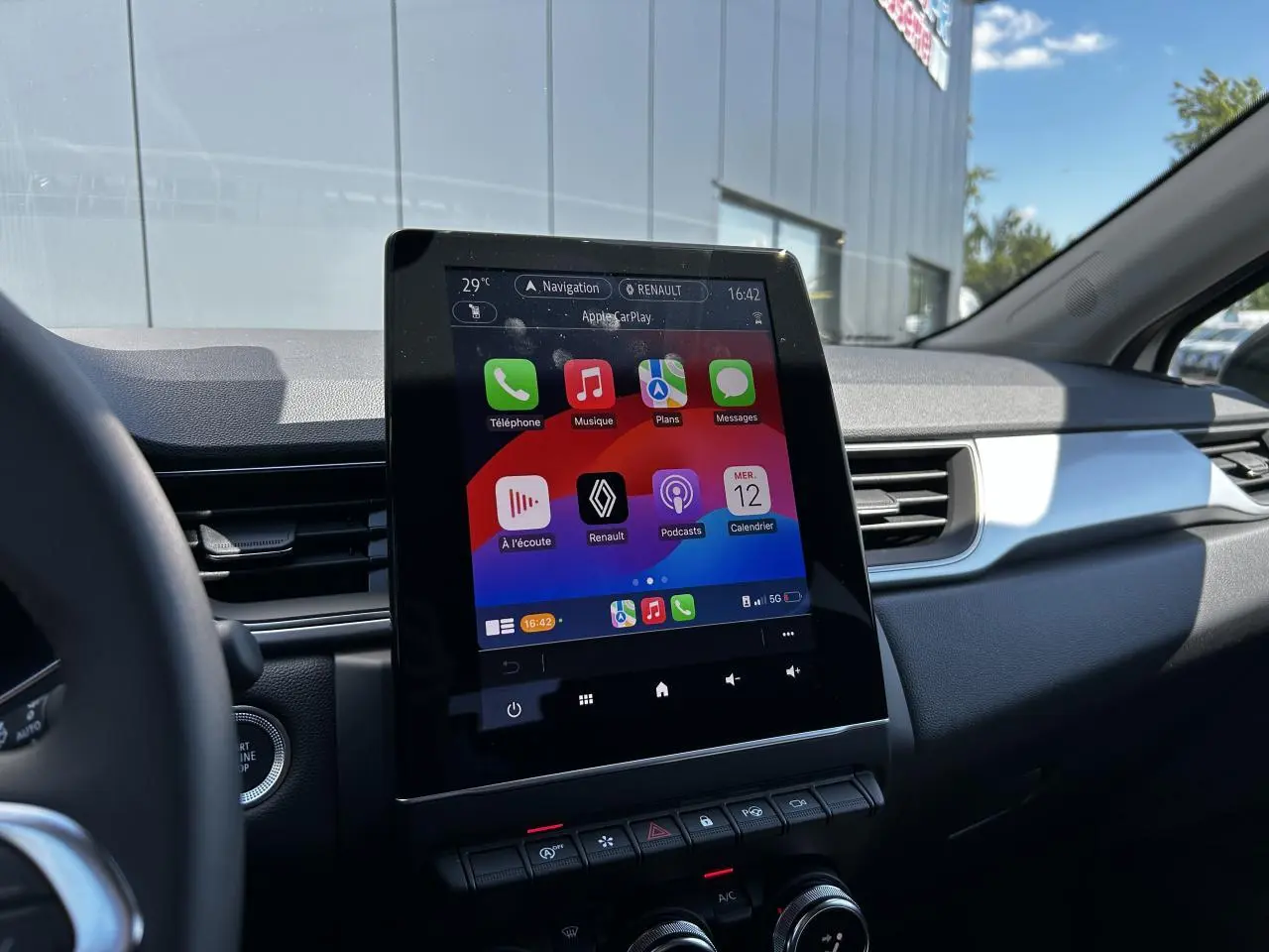 Vue intérieure du tableau de bord du Renault Captur 2024 avec écran tactile 9,3'' et interface Apple CarPlay.