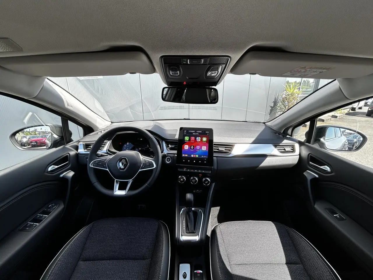 Vue intérieure avant du Renault Captur 2024 avec tableau de bord numérique et écran tactile central 9,3 pouces.