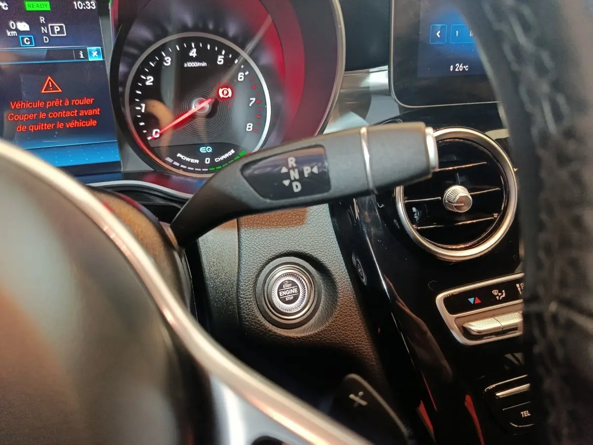 Gros plan sur le tableau de bord du Mercedes GLC 300 E bleu, avec bouton démarrage et levier de vitesses.