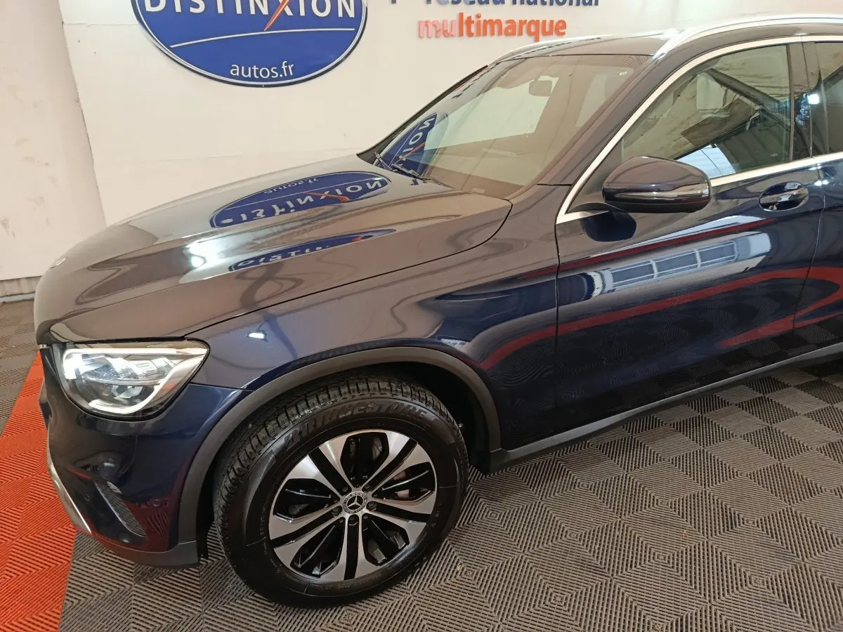 Vue 3/4 avant gauche d'un Mercedes GLC 300 E Business Line bleu avec jante alliage et phares LED visibles.