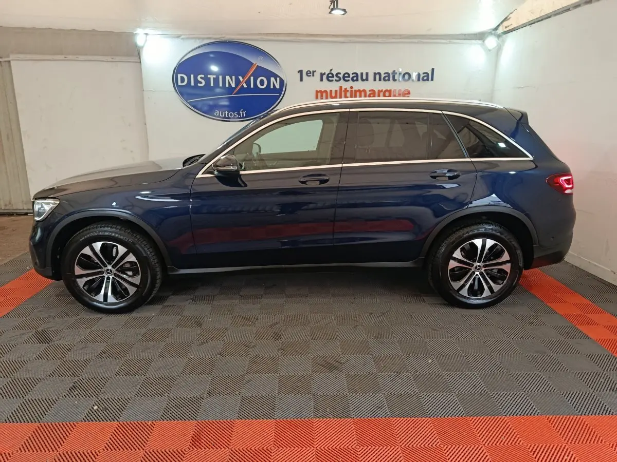 Profil côté gauche d'un Mercedes GLC 300 E Business Line 4MATIC bleu, avec jantes alliage et feux arrière allumés.