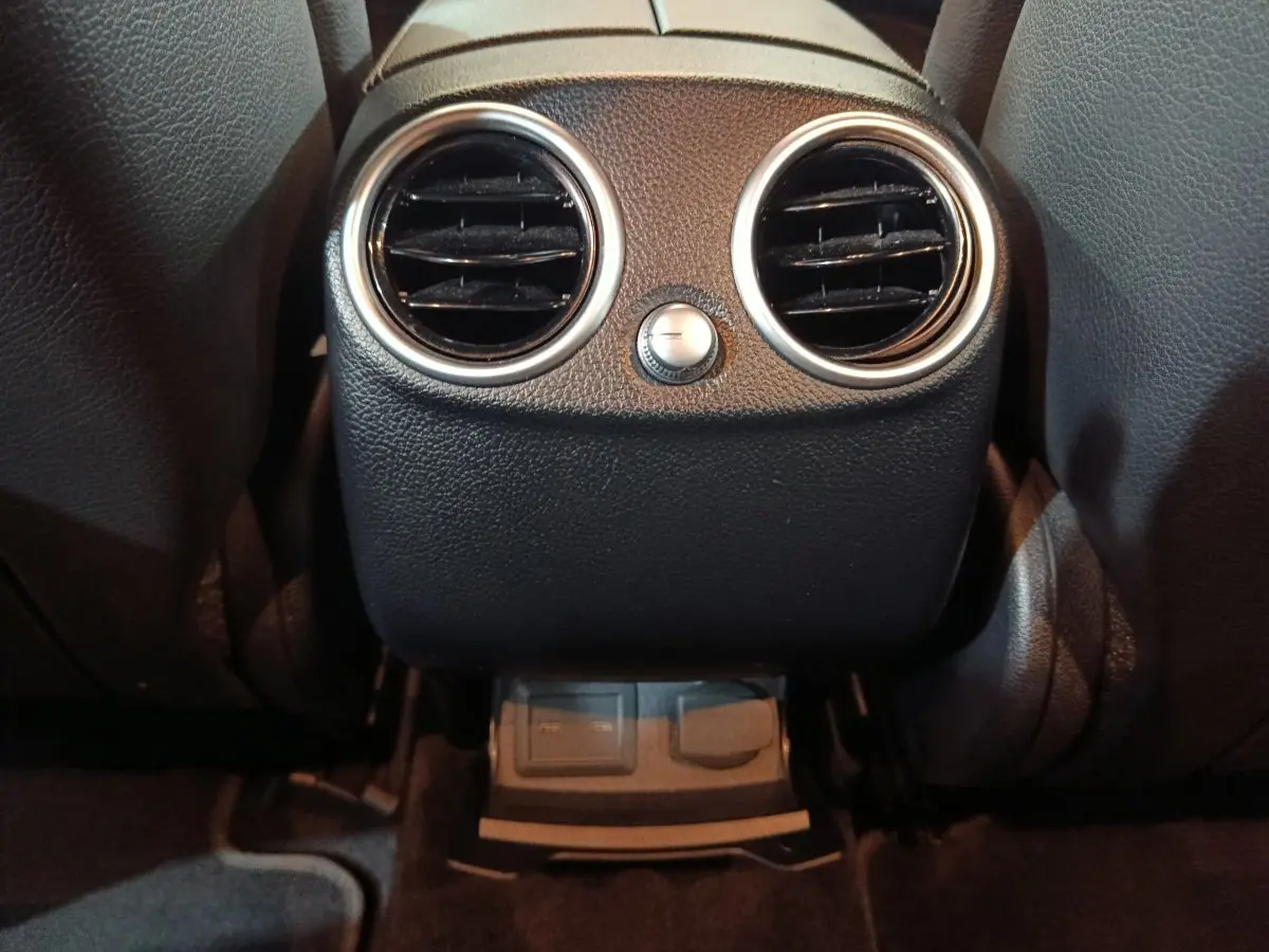 Vue rapprochée des aérateurs arrière noirs avec cerclages argentés dans l’habitacle du Mercedes GLC 300 E bleu 2021.